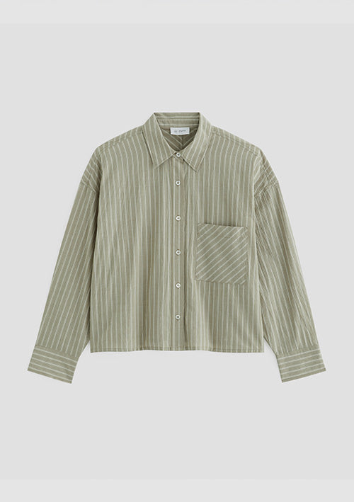 A long-sleeve button-up shirt with vertical stripes in sage green and cream, featuring a single chest pocket, shown on a neutral light gray background.