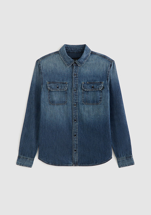 A blue denim long-sleeve button-up shirt with two buttoned chest pockets, displayed flat against a light gray background.