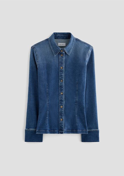 A blue denim long-sleeve button-up shirt with a pointed collar and button-front closure, shown flat against a light gray background.