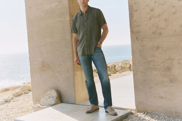 Man wearing a green shirt and blue jeans 