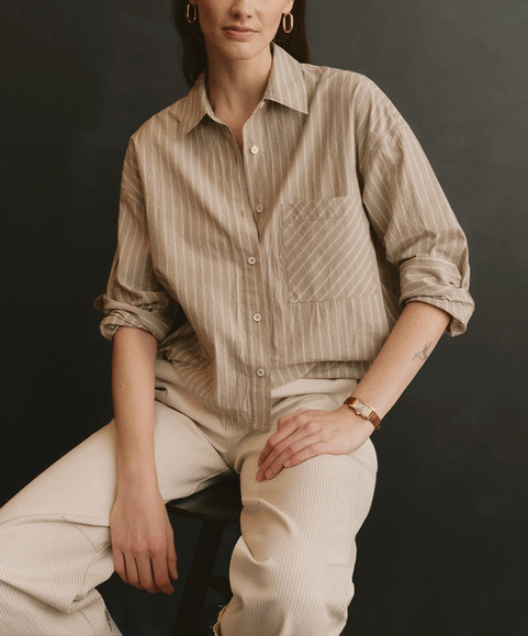 Two models posing in casual, earth-toned clothing against a dark studio background.