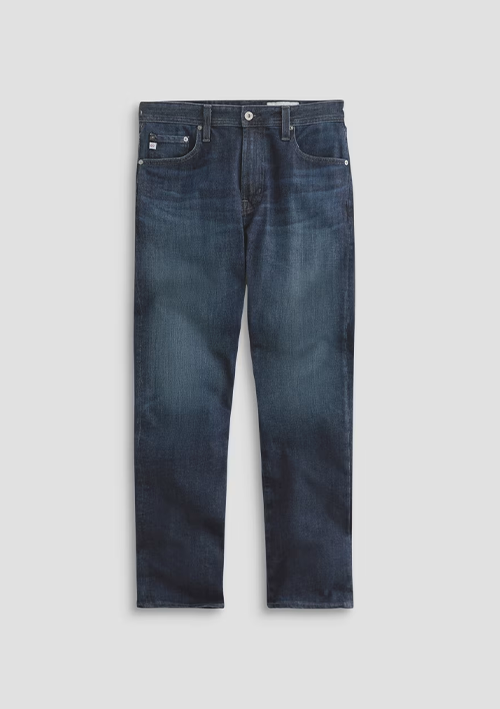 A pair of dark blue slim-fit jeans with subtle whiskering and fading, displayed flat against a light gray background.